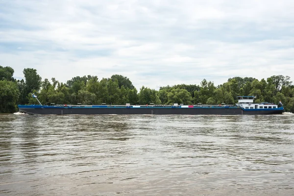 Bulutlu bir yaz gününde bir nehirde tanker mavnası. Nehir Ren, Almanya.