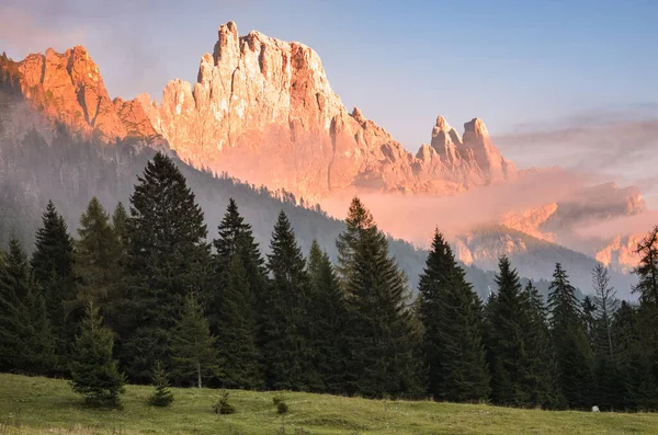 Sonbaharda batan güneşle kısmen sisle kaplanmış dağ zirvesi. Dolomitler, İtalya.