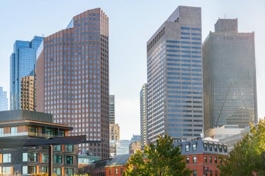 Sonbaharda günbatımında Boston 'da yüksek katlı ofis binaları. Bazı modern ve geleneksel apartmanlar ön planda görünür. MA, ABD.