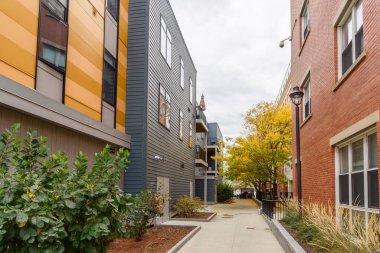 Bulutlu bir sonbahar gününde Boston, MA 'da deniz kenarındaki modern apartmanlar arasında terk edilmiş bir sokak.