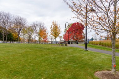 Açık deniz parkında piknik masaları ve bulutlu bir sonbahar gününde açık hava spor malzemeleri. Boston, MA, ABD.