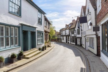Güneşli bir bahar gününde tarihi bir kasabada dükkanları ve restoranları olan geleneksel binalar. Çavdar, İngiltere, İngiltere.
