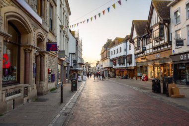 Canterbury, İngiltere - 9 Nisan 2025: Gün batımında yaya geçidi manzarası. Geçit töreni Canterbury şehir merkezinde sayısız dükkan ve restoranla dolu ticari bir cadde..