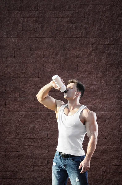 年轻人与强健的肌肉，训练后水喝 — 图库照片