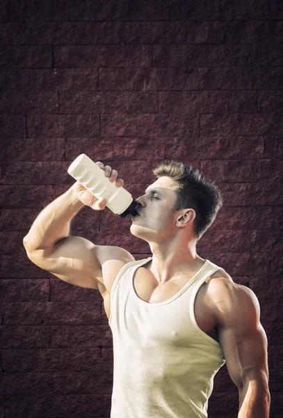 Jonge man met sterke spieren, water drinken na de training — Stockfoto