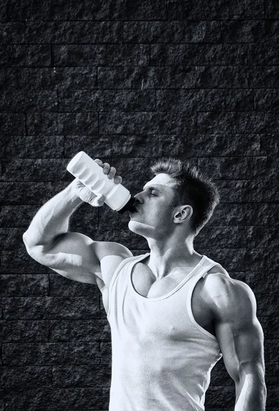 Jonge man met sterke spieren, water drinken na de training — Stockfoto