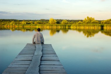Liman kenarında oturan yalnız adam
