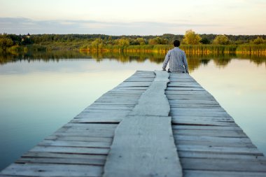 Liman kenarında oturan yalnız adam