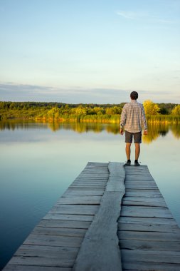 Yalnız adam bir iskele kenarında ayakta