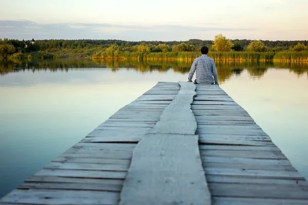 Liman kenarında oturan yalnız adam