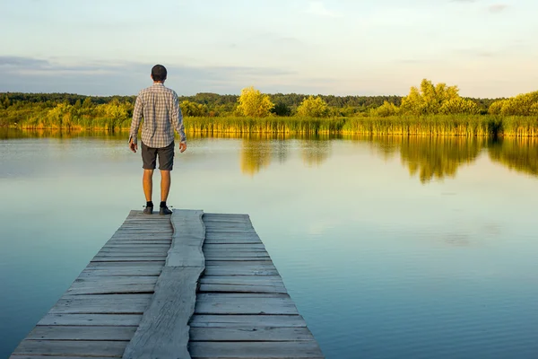 Yalnız adam bir iskele kenarında ayakta
