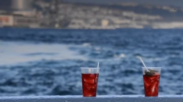 Смачний червоний чай з лимоном на фоні моря і кораблів — стокове відео