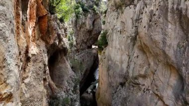 Dar bir kanyon geçidinde sürekli süzülürken sinematik hava görüntüsünü yakalıyoruz. Etrafımız heybetli yüksek uçurumlarla ve aşağıdan akan sakin bir nehirle çevrili.