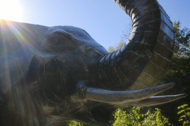 Büyük metalik bir fil heykeli. Güneş ışıldıyor..