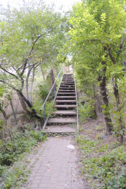 Uzun bir merdiven bir tepeye tırmanır, tuğla bir patikadan uzaklaşır..
