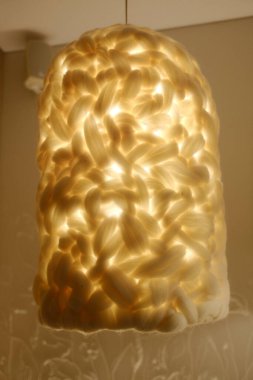 Beyaz ışık garip şekilli bir lambanın içinden parlıyor..