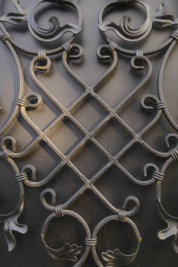 Siyah metaller eğrili ve geometrik şekilli karmaşık bir desen gösterirler.