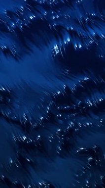 Koyu mavi, parlak boya dalgalanır, yavaşça güzel dalgalanmalar ve dokular yaratır..