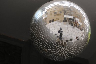 Koyu tavandan sarkıtılmış büyük gümüş disko topu.