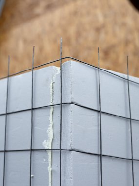 Yapı detaylarını ve duvar yalıtım sürecini gösteren takviye ağlarına yerleştirilmiş polistiren köpük eklemlerinin yakın plan görüntüleri.