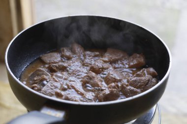 close-up meat in a frying pan