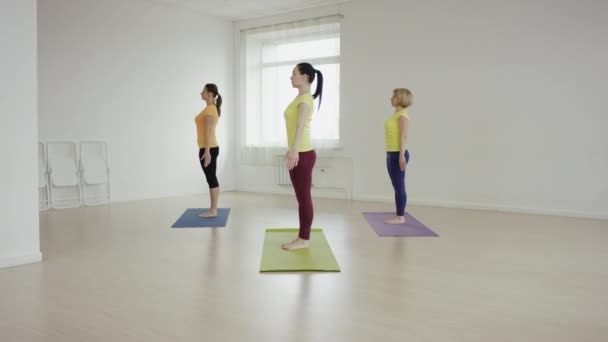 Clase de yoga haciendo pose juntos en colchonetas de ejercicio en el gimnasio — Vídeos de Stock