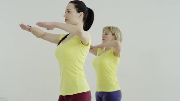 Fitness, deporte, entrenamiento y estilo de vida - grupo de mujeres sonrientes que se estiran en el gimnasio — Vídeos de Stock