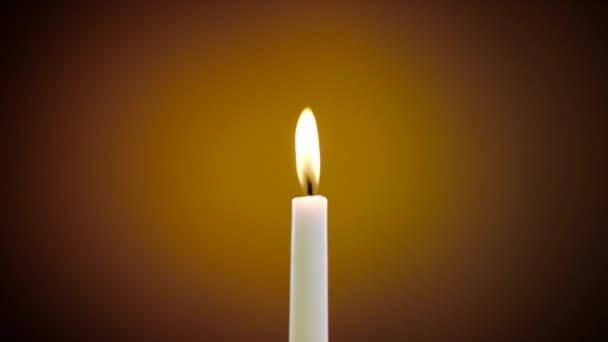 Burning candle on a yellow background — Stock Video