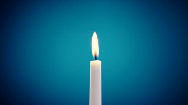 Burning candle on a blue background — Stock Video