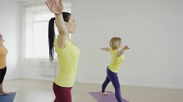 Yoga class doing cobra pose together on exercise mats at the gym — Stock Video