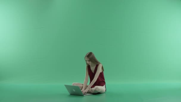 Woman writes a message on the laptop on a green screen — Stock Video