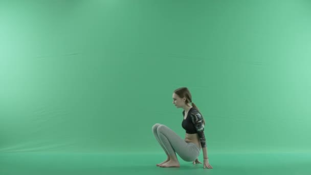 Mujer en postura de yoga en una pantalla verde — Vídeo de stock