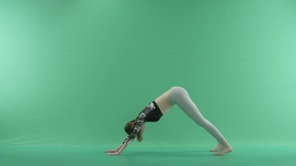 Mujer en postura de yoga en una pantalla verde — Vídeo de stock