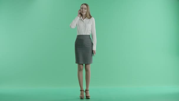 Business woman talking on two phones at the same time on a green screen — Stock Video