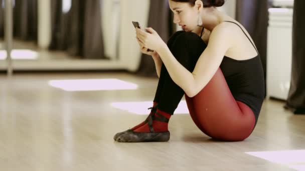 Hermosa chica usando ballet leotardo con teléfono celular — Vídeo de stock