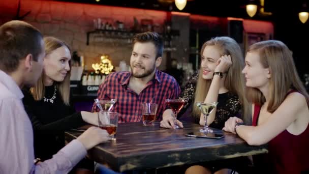 Verlegen meisje vertelt iets grappig in de bar — Stockvideo