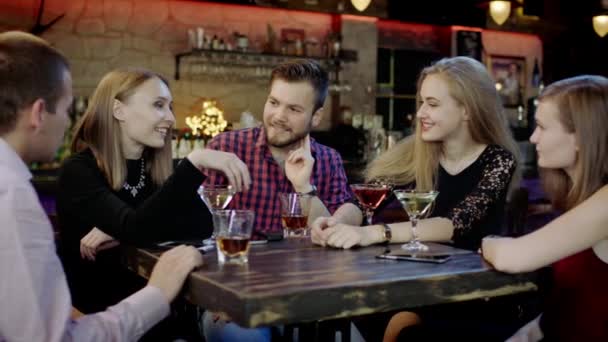 Företaget av ungdomar chattar och leende i baren — Stockvideo