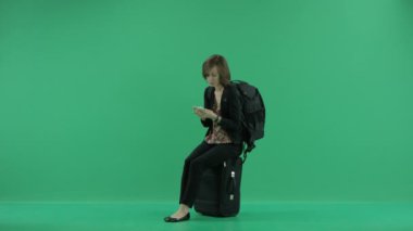 Çantayı üzerinde oturan kadın turist bekler