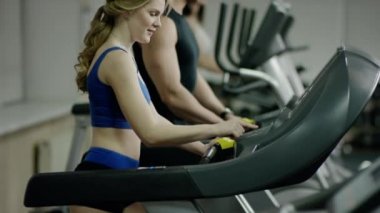 Gülümseyen kadın koşu bandında yürüyüş