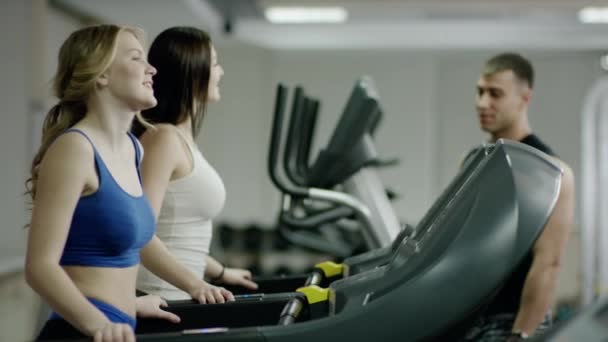 在跑步机上适合教练和年轻的女人 — 图库视频影像