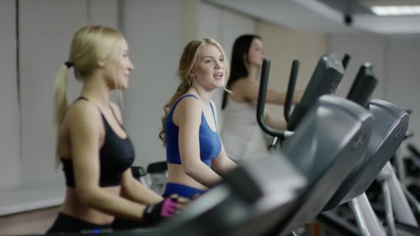 Duas jovens mulheres loiras andando na esteira — Vídeo de Stock