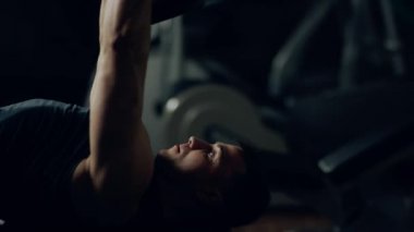 bir spor salonunda bir bankta bir Dumbbell kazak egzersiz yapan erkek.