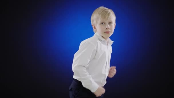 Roztomilý chlapec tančí na modré obrazovce — Stock video