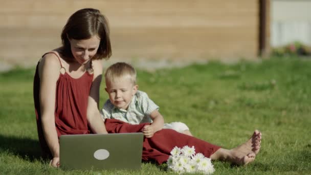 Děti při pohledu na obrázek notebook se svou matkou v parku — Stock video