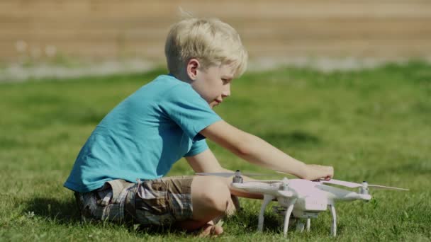 Dziecko, montaż nowoczesnych drona na zielonym trawniku. Stawianie na śmigła — Wideo stockowe