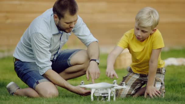 Father and son study quadrocopter drone — Stock Video