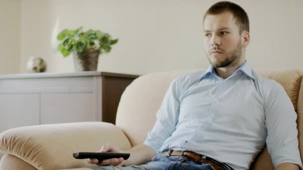 Мужчина сидит перед телевизором — стоковое видео