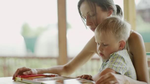 Mutter und Sohn lesen ein Buch — Stockvideo