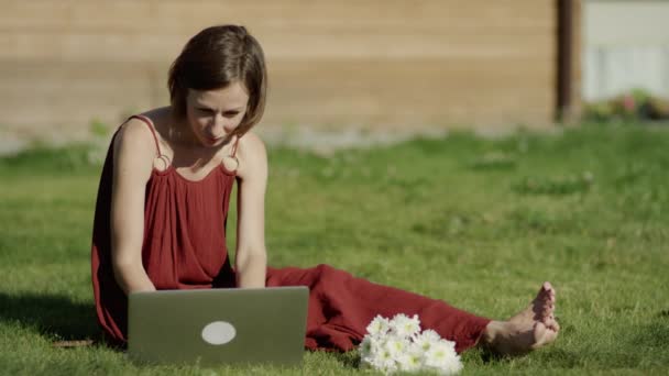 Chica utilizando la tecnología en un prado con portátil — Vídeo de stock