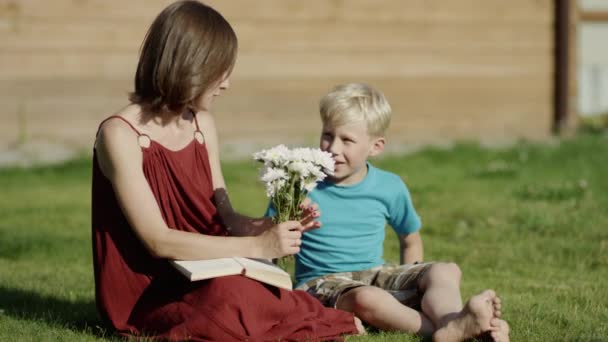 Sohn schenkt Mama Blumen Sommer, Wiese — Stockvideo